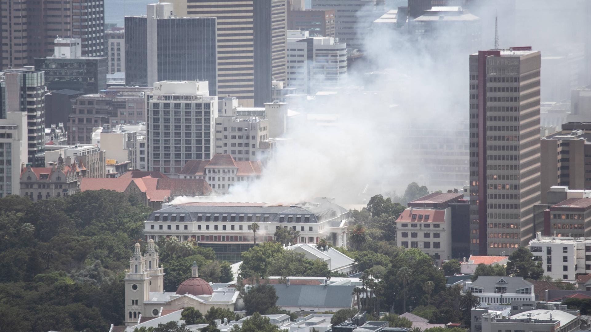 Hochhäuser im südafrikanischen Kapstadt. Über dem Parlament steht eine dunkle Rauchwolke von einem Brand.