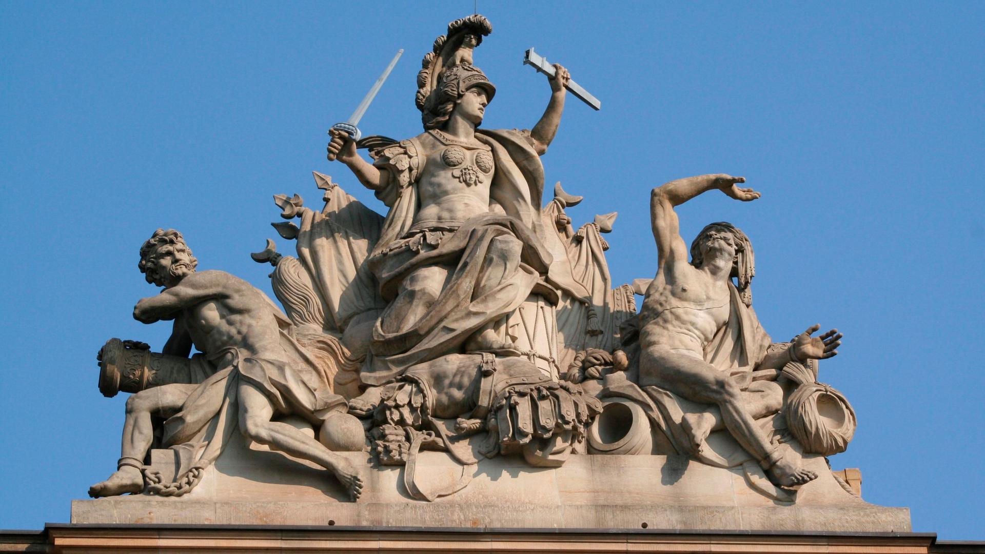 Auf dem Berliner Zeughaus ist eine Stein-Statue des römischen Kriegsgottes Mars, der seine Feinde unterwirft.