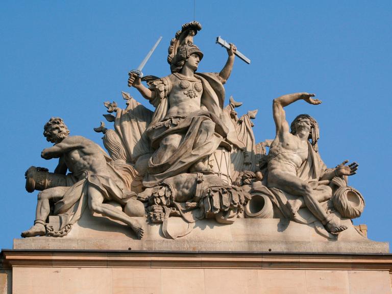 Auf dem Berliner Zeughaus ist eine Stein-Statue des römischen Kriegsgottes Mars, der seine Feinde unterwirft.