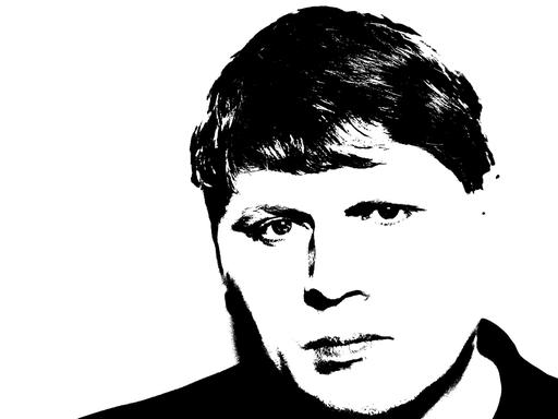 Sergej Newski blickt auf einem schwarz-weiß-Foto ernst in die Kamera.