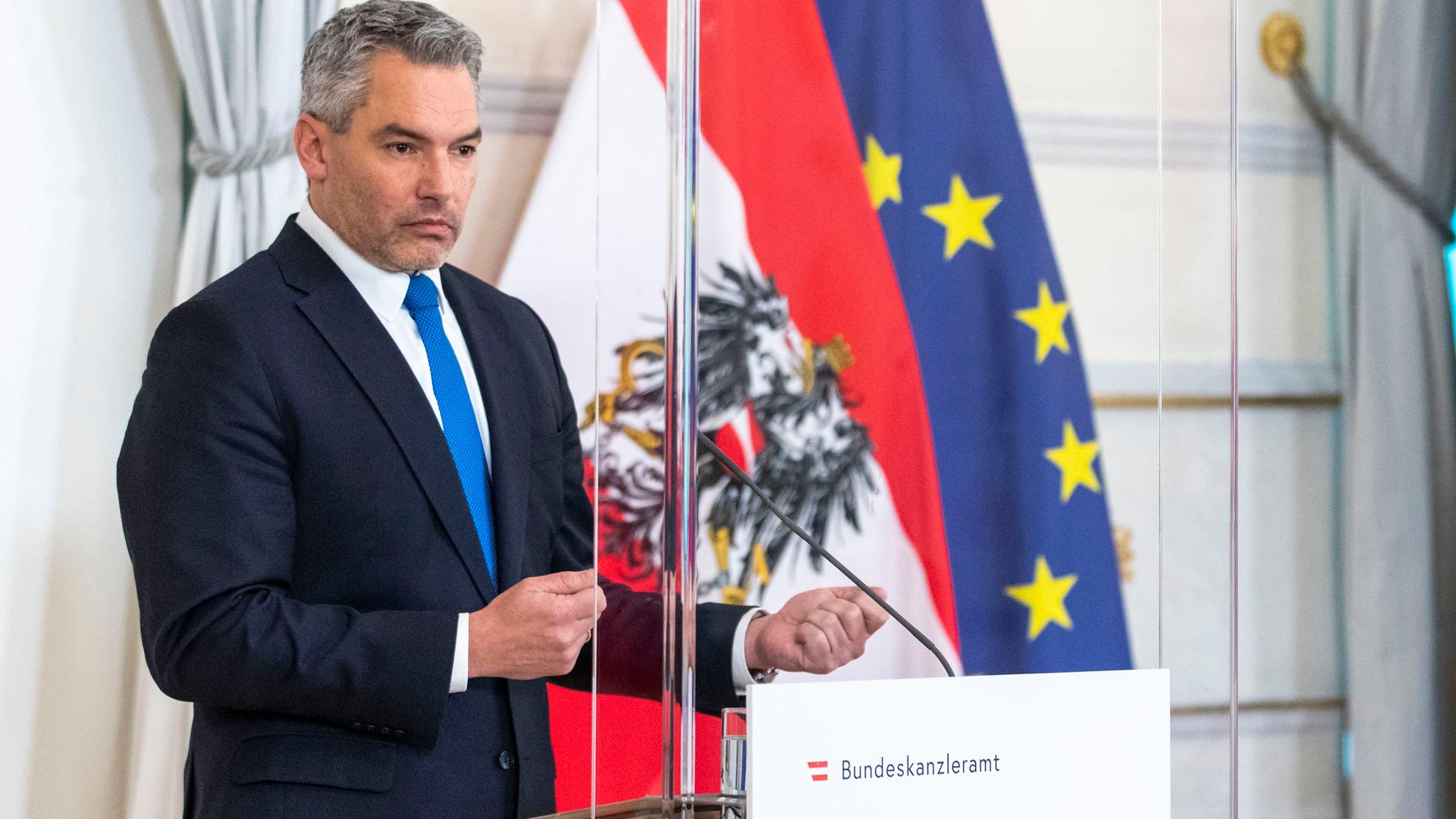 Der österreichische Bundes-Kanzler Nehammer steht vor einem Mikrofon.