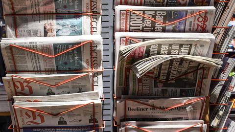 Zeitungen stecken in einem Zeitungsständer