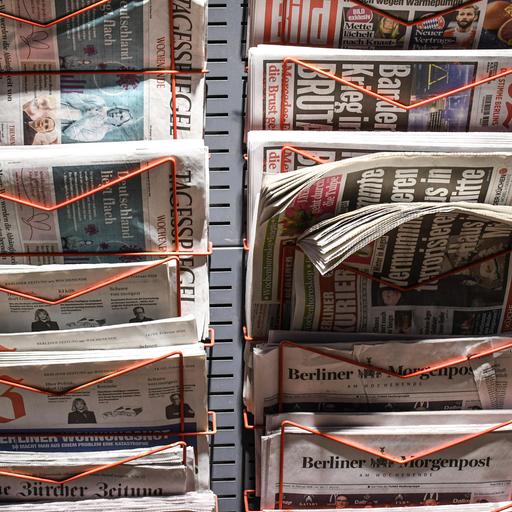 Zeitungen stecken in einem Zeitungsständer