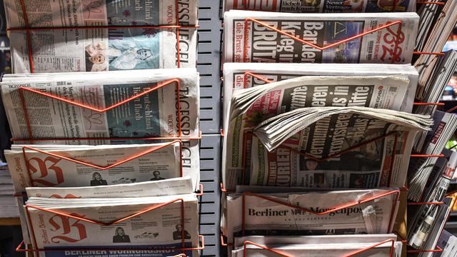 Zu sehen sind mehrere Zeitungen. Die Zeitungen stecken in einem Ständer.