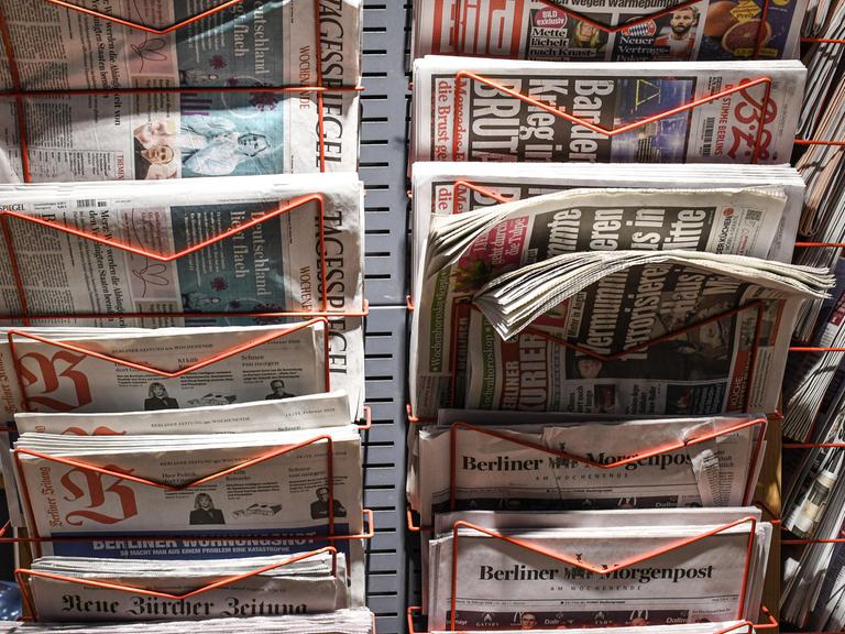 Zeitungen stecken in einem Zeitungsständer