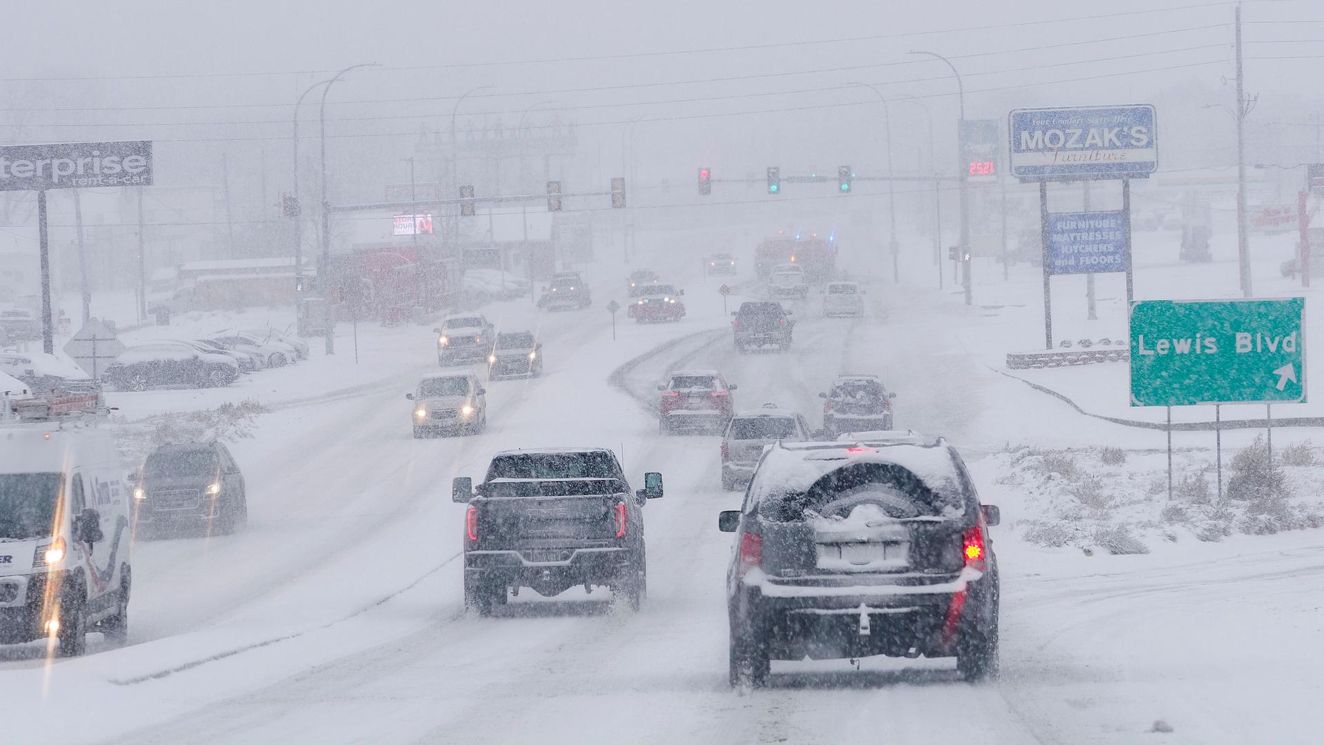 Sioux-Stadt: Der Verkehr staut sich bei Schneefall auf einer schneebedeckten Straße. Sioux-Stadt: Der Verkehr staut sich bei Schneefall auf einer schneebedeckten Straße.