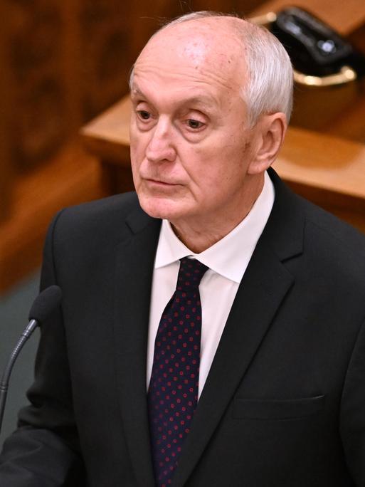 Der neue ungarische Präsident András Baka bei der Vereidigung in der Nationalversammlung. Er trägt einen schwarzen Anzug, hat schütteres Herr und blickt ernst. 
