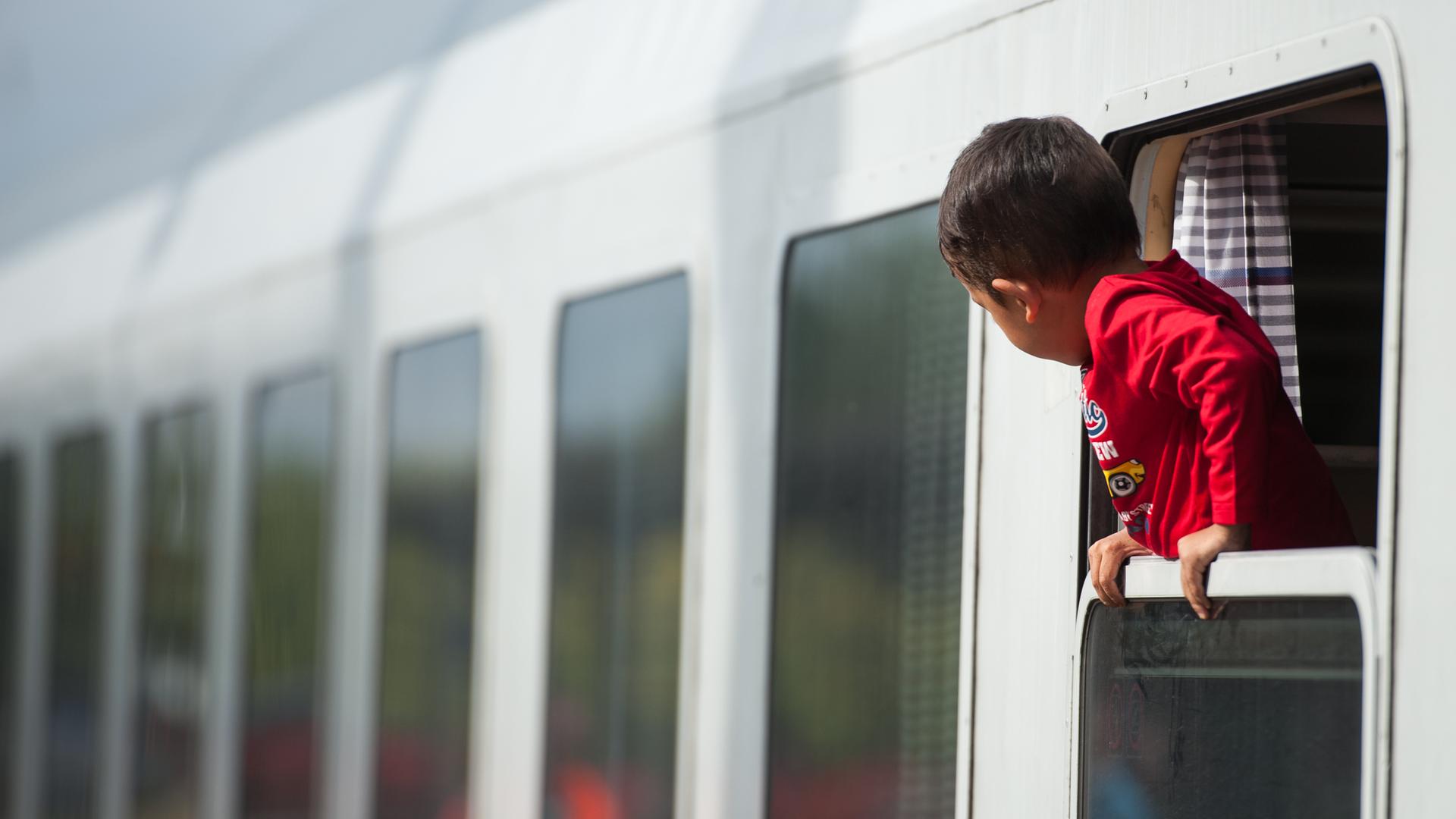 Ein Flüchtlingskind blickt am 13.09.2015 am Bahnhof von Uelzen (Niedersachsen) aus einem ankommenden Zug.