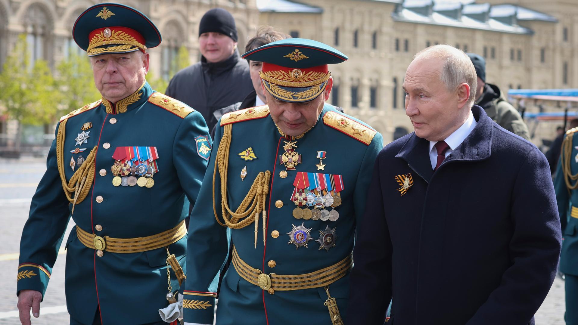 Der Oberbefehlshaber der russischen Bodentruppen Oleg Saljukow (links), der russische Verteidigungsminister Sergej Schoigu (Mitte), und der Präsident Wladimir Putin verlassen den Roten Platz nach der Militärparade zum "Tag des Sieges", Moskau 9. Mai 2024.