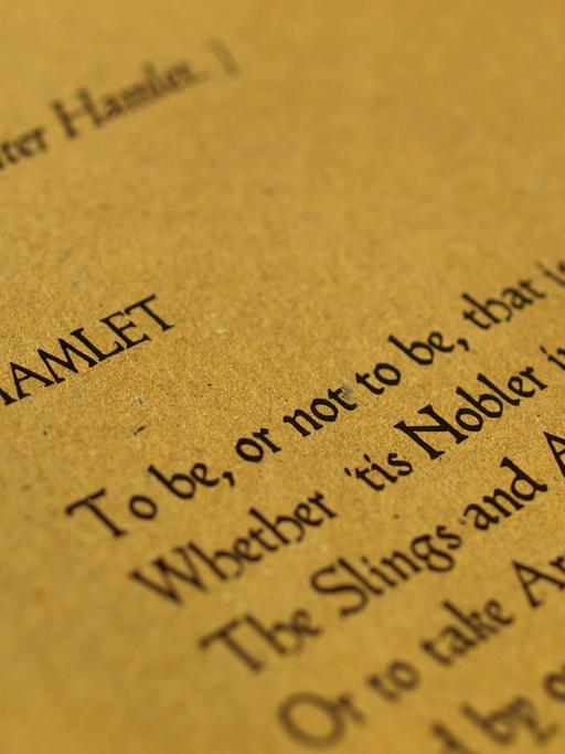 Auf dem Bild ist ein altes Papier zu sehen auf dem Hamlets berühmte Aussage: "To be, or not to be, that is the question", steht. 