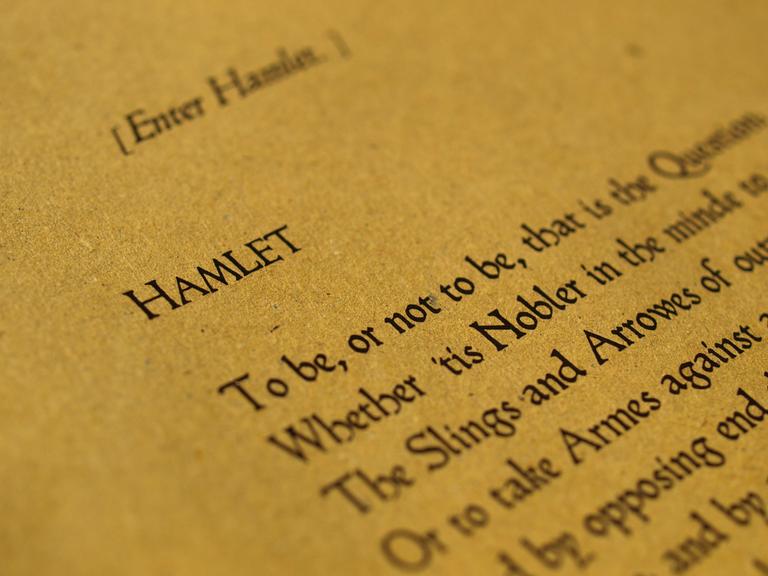 Auf dem Bild ist ein altes Papier zu sehen auf dem Hamlets berühmte Aussage: "To be, or not to be, that is the question", steht. 