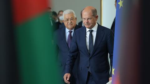 Mahmoud Abbas (L), Präsident der Palästinensischen Autonomiebehörde, und Bundeskanzler Olaf Scholz eingerahmt zwischen den offiziellen Flaggen während der Pressekonferenz.