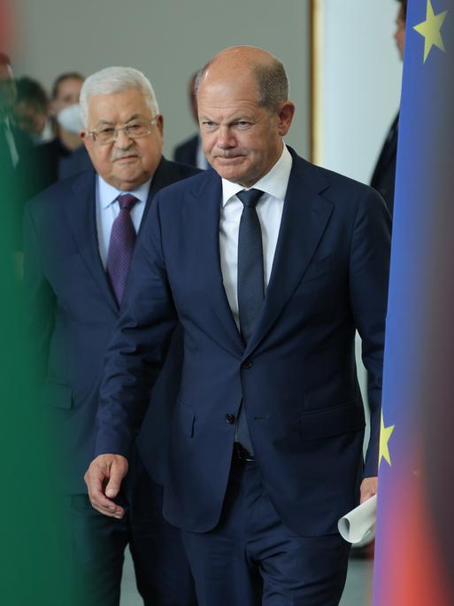 Mahmoud Abbas (L), Präsident der Palästinensischen Autonomiebehörde, und Bundeskanzler Olaf Scholz eingerahmt zwischen den offiziellen Flaggen während der Pressekonferenz.