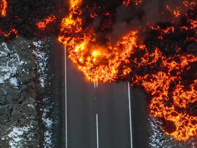 Geschmolzene Lava auf der Straße zur Blauen Lagune in Grindavik auf der Halbinsel Reykjanes auf Island Geschmolzene Lava auf der Straße zur Blauen Lagune in Grindavik auf der Halbinsel Reykjanes auf Island