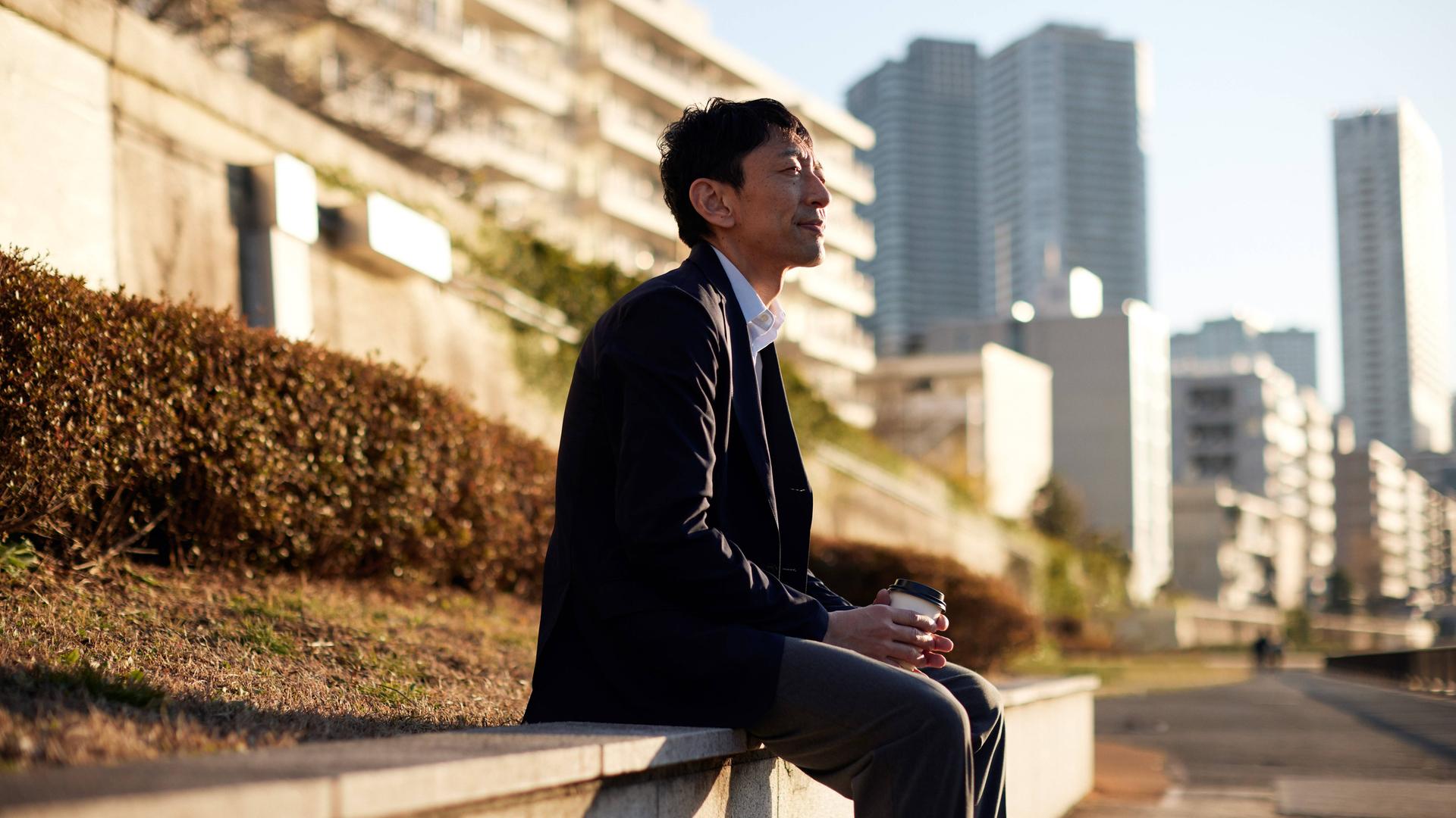 Ein japanischer Mann sitzt in der Sonne