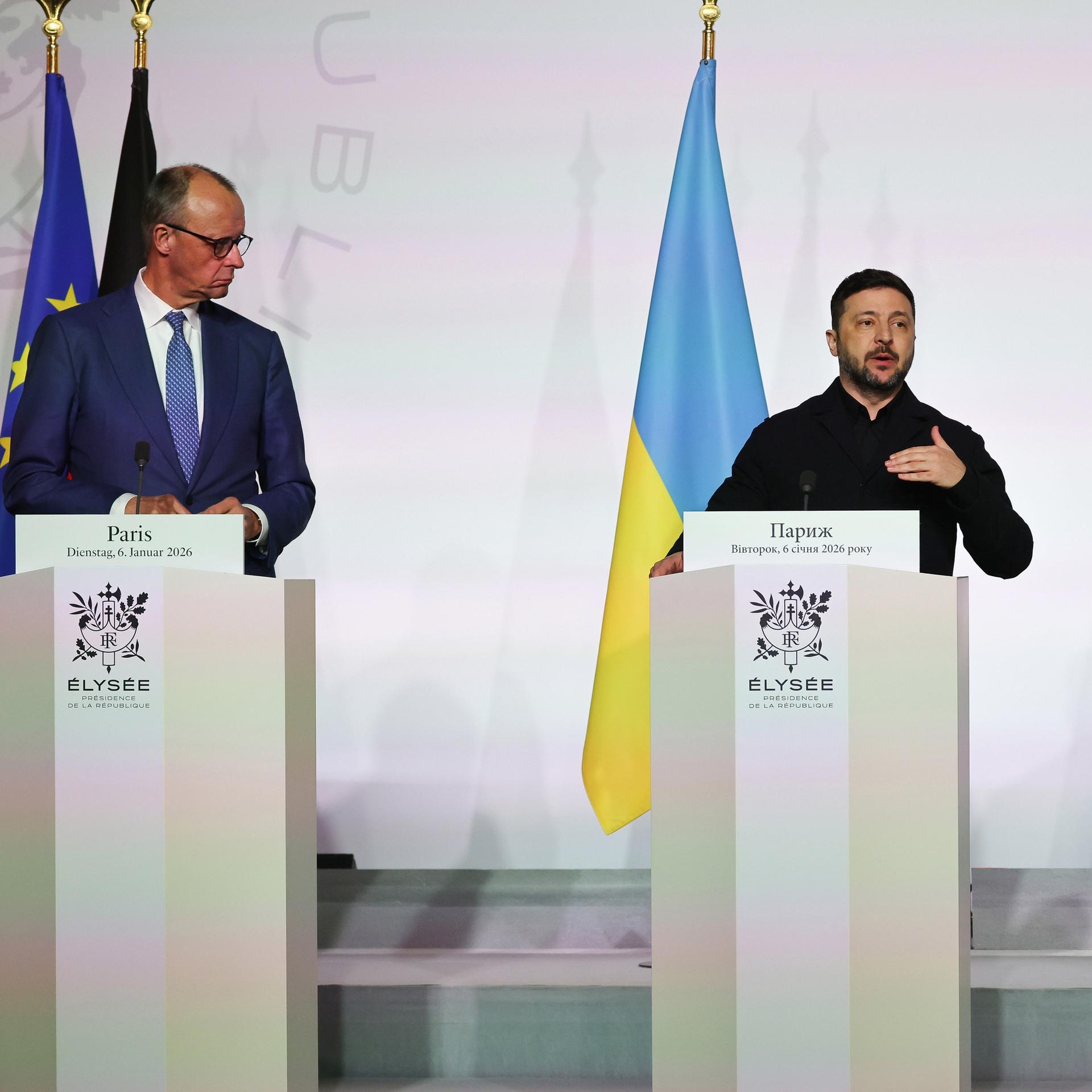 Bundeskanzler Merz, der ukrainische Präident Selenskyj und Frankreichs Präsident Macron stehen hinter Rednerpulten. Neben ihnen die Flaggen der EU, Deutschlands, der Ukraine und Frankreichs