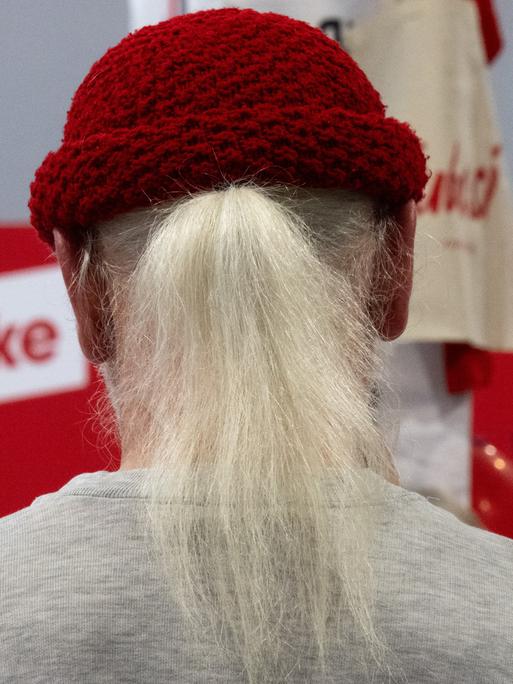 Ein Teilnehmer des Bundesparteitages der Partei Die Linke sitzt unter einem Parteilogo im Ausstellerbereich . Nach drei Tagen endet der Parteitag am Sonntag.