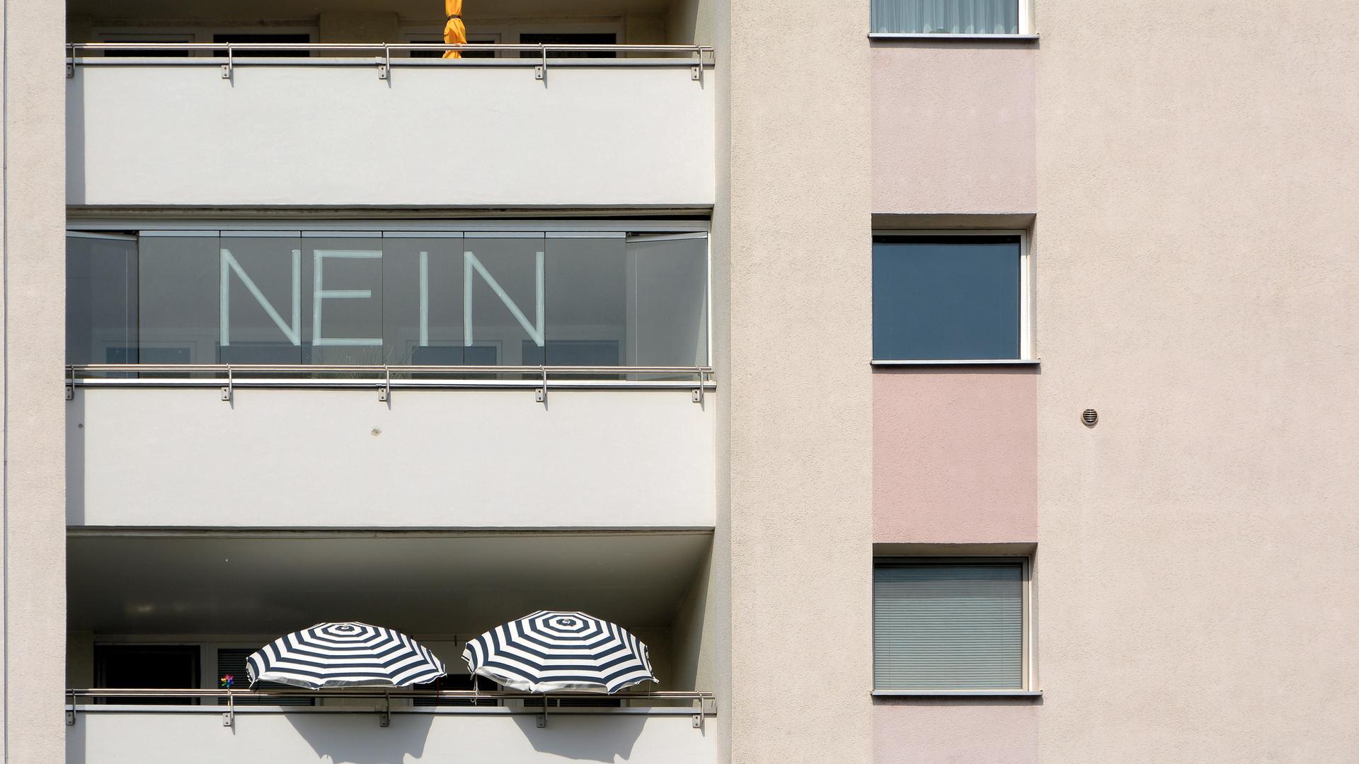 An einem Balkon steht gross das Wort "Nein".