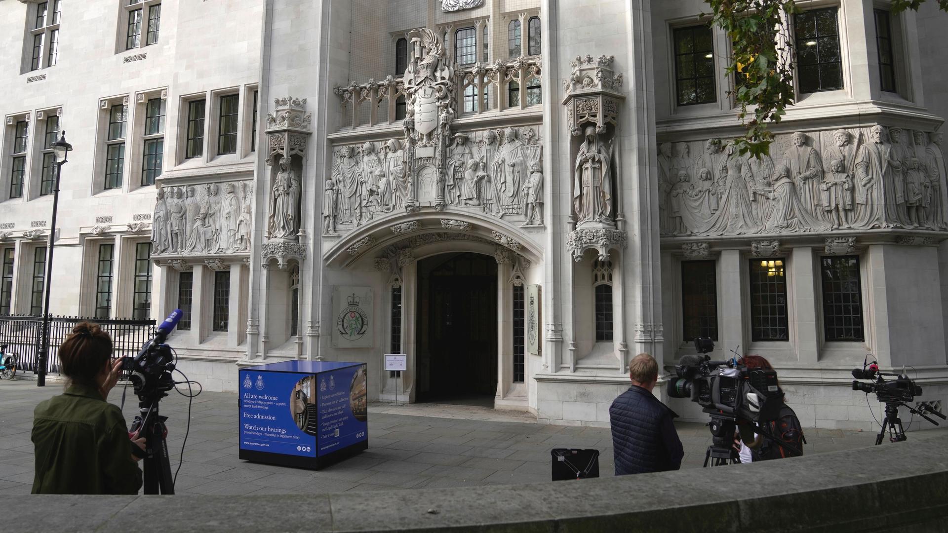 Journalisten stehen mit Kameras vor dem Supreme Court in London.
