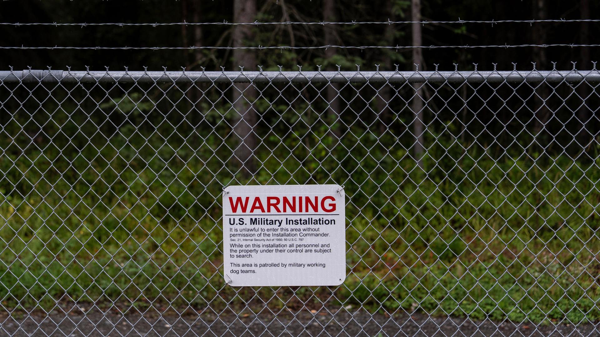 Ein Warnschild ist an einem Maschendrahtzaun vor dem Eingangstor zur des Militärstützpunkts Elmendorf-Richardson in Anchorage, Alaska, angebracht.