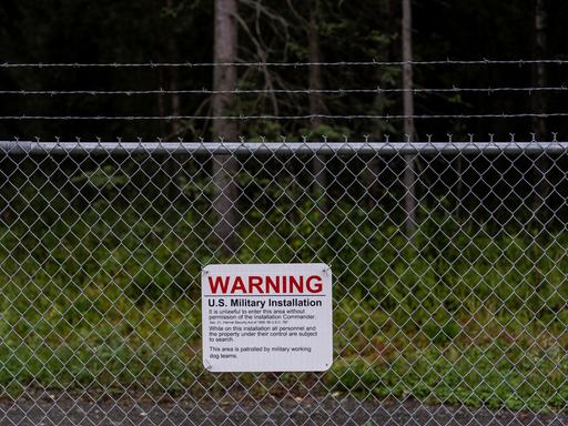 Ein Warnschild ist an einem Maschendrahtzaun vor dem Eingangstor zur des Militärstützpunkts Elmendorf-Richardson in Anchorage, Alaska, angebracht.