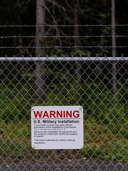 Ein Warnschild ist an einem Maschendrahtzaun vor dem Eingangstor zur des Militärstützpunkts Elmendorf-Richardson in Anchorage, Alaska, angebracht.