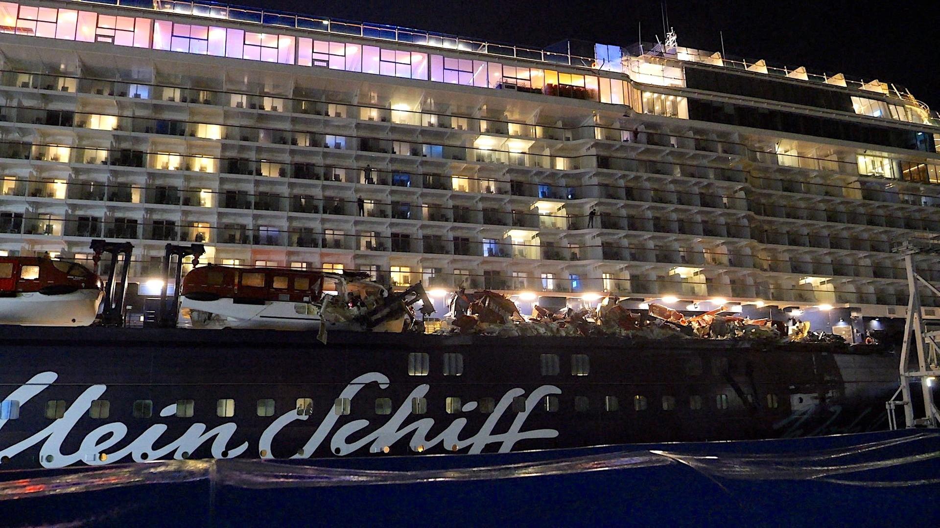 Nachtaufnahme der Bordwand der "Mein Schiff 3" mit Schrammen und zerdrückten Rettungsbooten