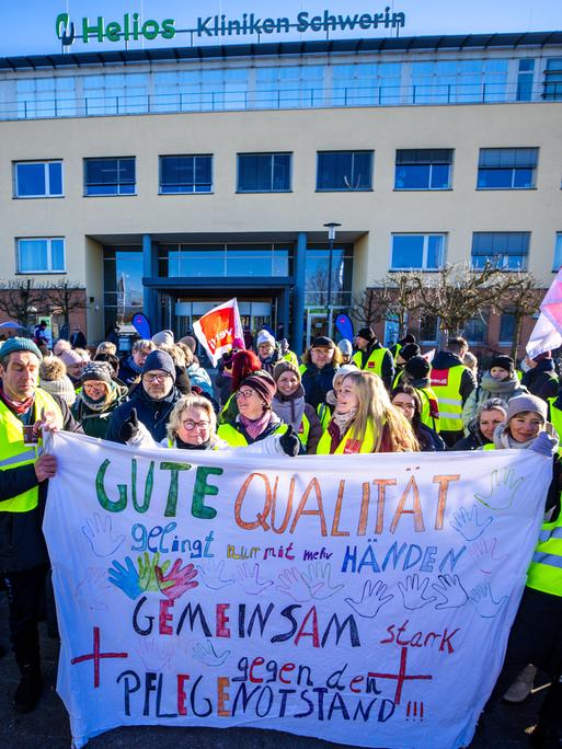 Beschäftigte des Helios-Klinikum stehen vor dem Hauptgebäude des Krankenhaus und beteiligen sich an einem zweitägigen Warnstreik für mehr Lohn und bessere Arbeitsbedingungen.