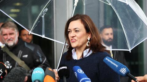Franziska Hoppermann steht vor mehreren Mikrofonen und spricht.