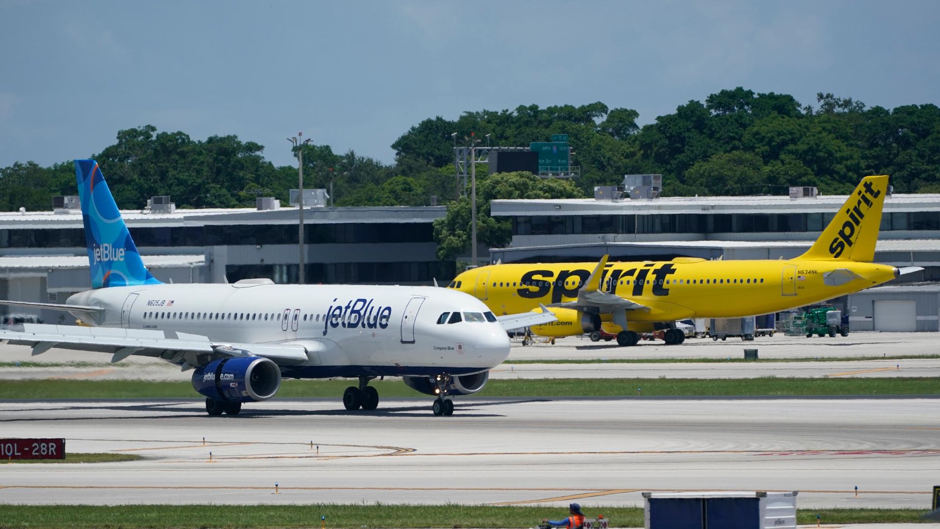 Ein Airbus A320 von JetBlue Airways (l) überholt einen Airbus A320 von Spirit Airlines auf der Rollbahn auf dem Fort Lauderdale-Hollywood International Airport. Ein Airbus A320 von JetBlue Airways (l) überholt einen Airbus A320 von Spirit Airlines auf der Rollbahn auf dem Fort Lauderdale-Hollywood International Airport.