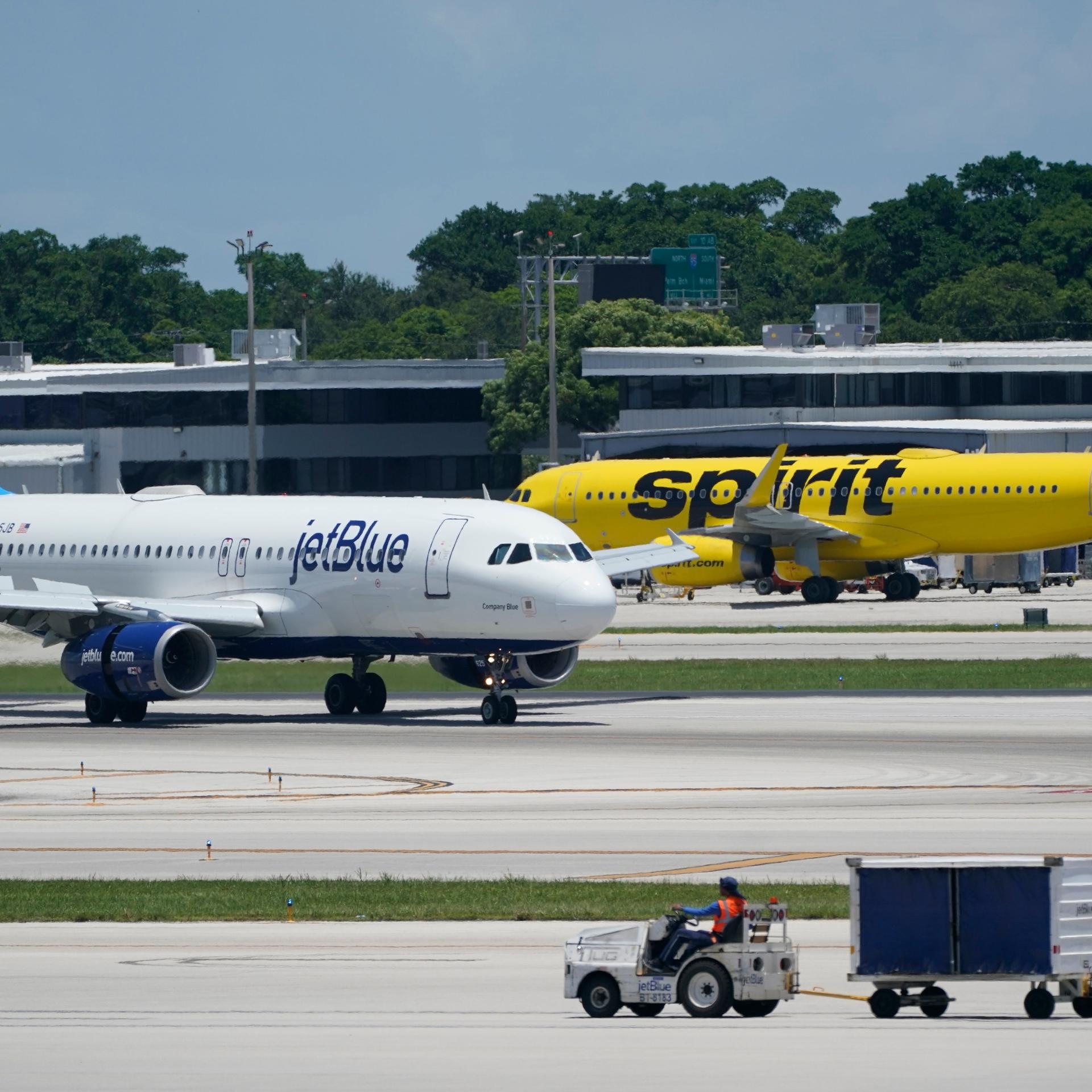 Ein Airbus A320 von JetBlue Airways (l) überholt einen Airbus A320 von Spirit Airlines auf der Rollbahn auf dem Fort Lauderdale-Hollywood International Airport. 