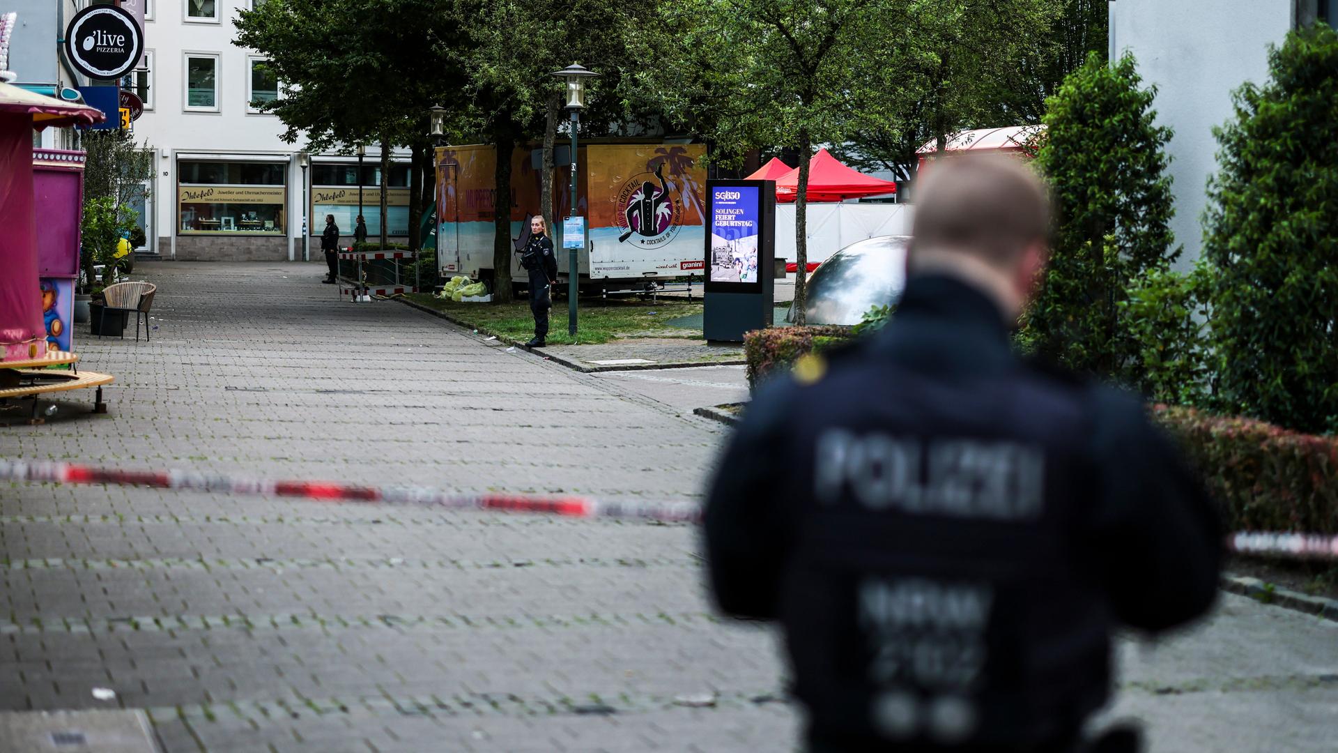 Ein Polizist steht am frühen Morgen an einer Absperrung. 