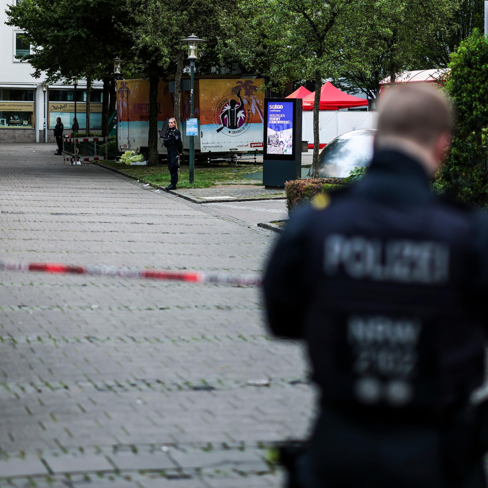 Ein Polizist steht am frühen Morgen an einer Absperrung. 