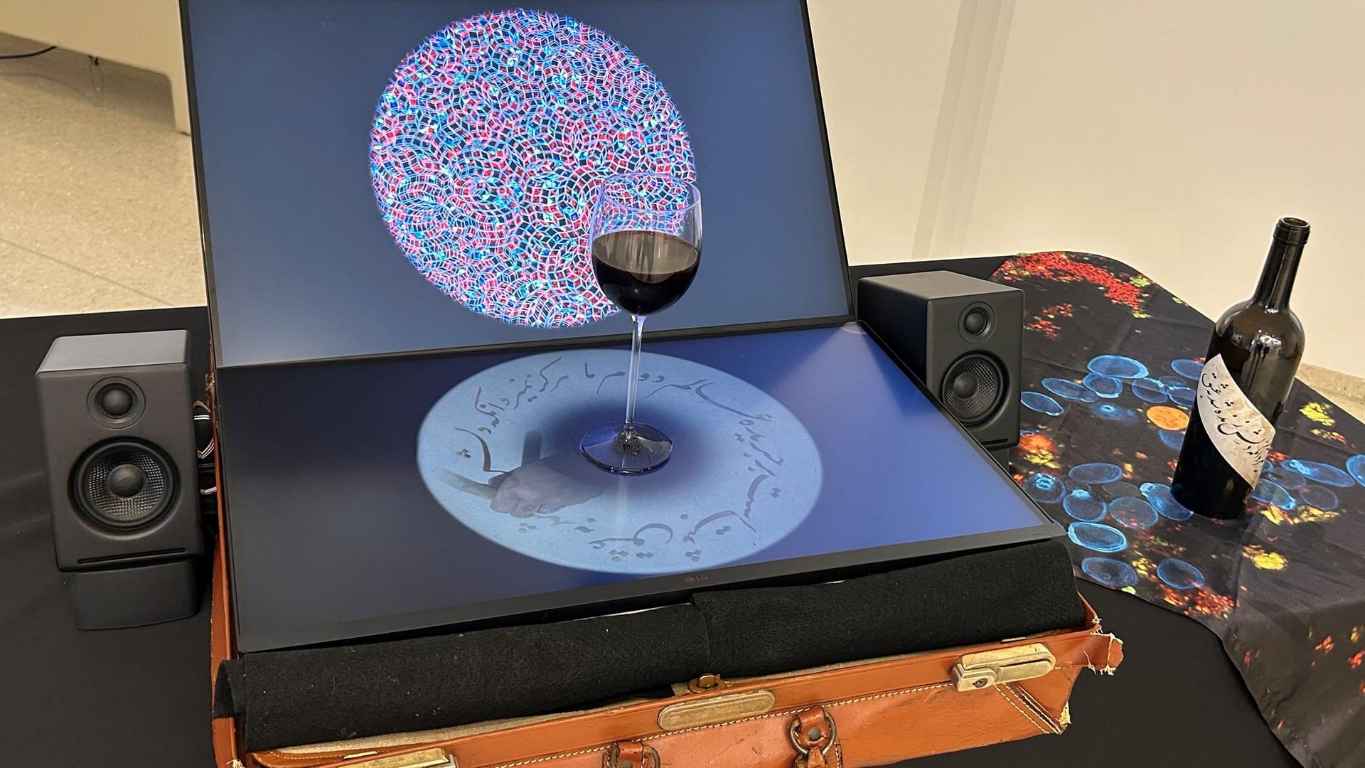 Eine Komposition aus einem alten Lederkoffer, darauf ein geöffneter Laptop mit einem Glas Rotwein Eine Komposition aus einem alten Lederkoffer, darauf ein geöffneter Laptop mit einem Glas Rotwein