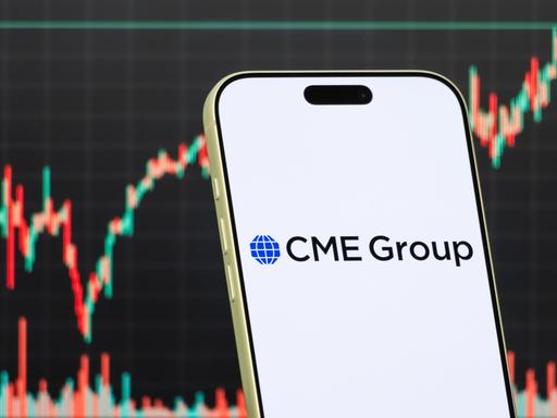 Diese Fotomontage zeigt das Logo der CME Group auf einem Smartphone vor einem Bildschirm, der den aktuellen Aktienmarkt-Chart des Unternehmens anzeigt. Diese Fotomontage zeigt das Logo der CME Group auf einem Smartphone vor einem Bildschirm, der den aktuellen Aktienmarkt-Chart des Unternehmens anzeigt.