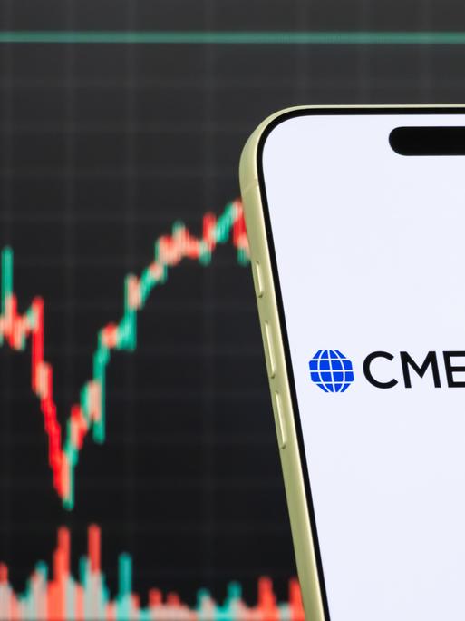 Diese Fotomontage zeigt das Logo der CME Group auf einem Smartphone vor einem Bildschirm, der den aktuellen Aktienmarkt-Chart des Unternehmens anzeigt. Diese Fotomontage zeigt das Logo der CME Group auf einem Smartphone vor einem Bildschirm, der den aktuellen Aktienmarkt-Chart des Unternehmens anzeigt.