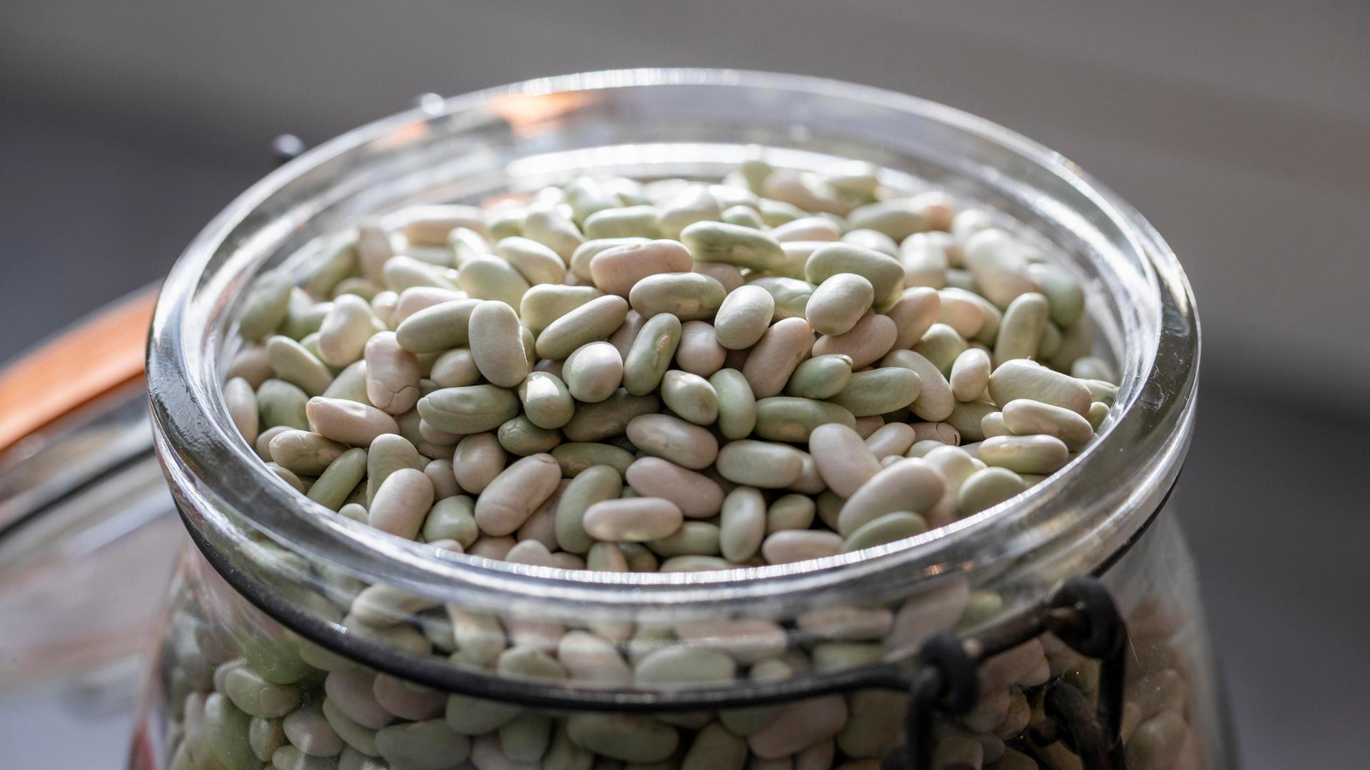 Weiße Bohnen liegen in einer Glasschale.