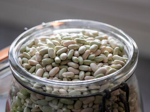 Weiße Bohnen liegen in einer Glasschale.