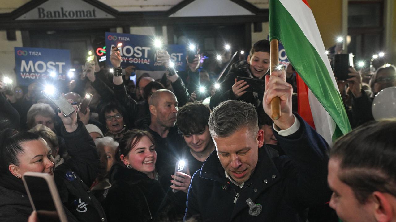 Der ungarische Oppositionsführer Peter Magyar,  vonder  TISZA (Respect and Freedom) Partei, trägt die ungarische Flagge durch eine Menschenmenge von unterstützenden Menschen.