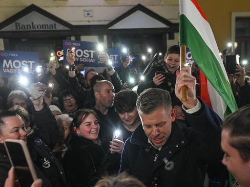 Der ungarische Oppositionsführer Peter Magyar,  vonder  TISZA (Respect and Freedom) Partei, trägt die ungarische Flagge durch eine Menschenmenge von unterstützenden Menschen.