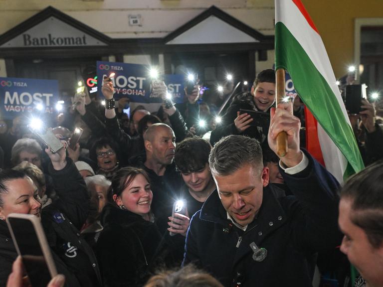 Der ungarische Oppositionsführer Peter Magyar,  vonder  TISZA (Respect and Freedom) Partei, trägt die ungarische Flagge durch eine Menschenmenge von unterstützenden Menschen.