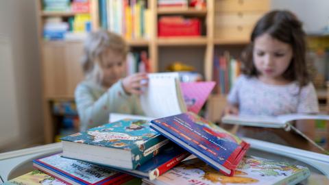 Kinder blättern in einem Kinderzimmer in Leipzig in Kinderbüchern.