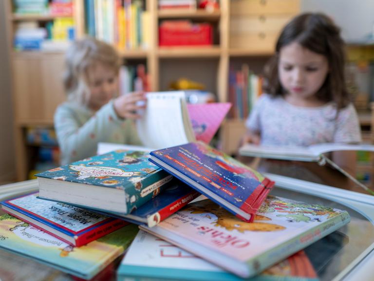 Kinder blättern in einem Kinderzimmer in Leipzig in Kinderbüchern.