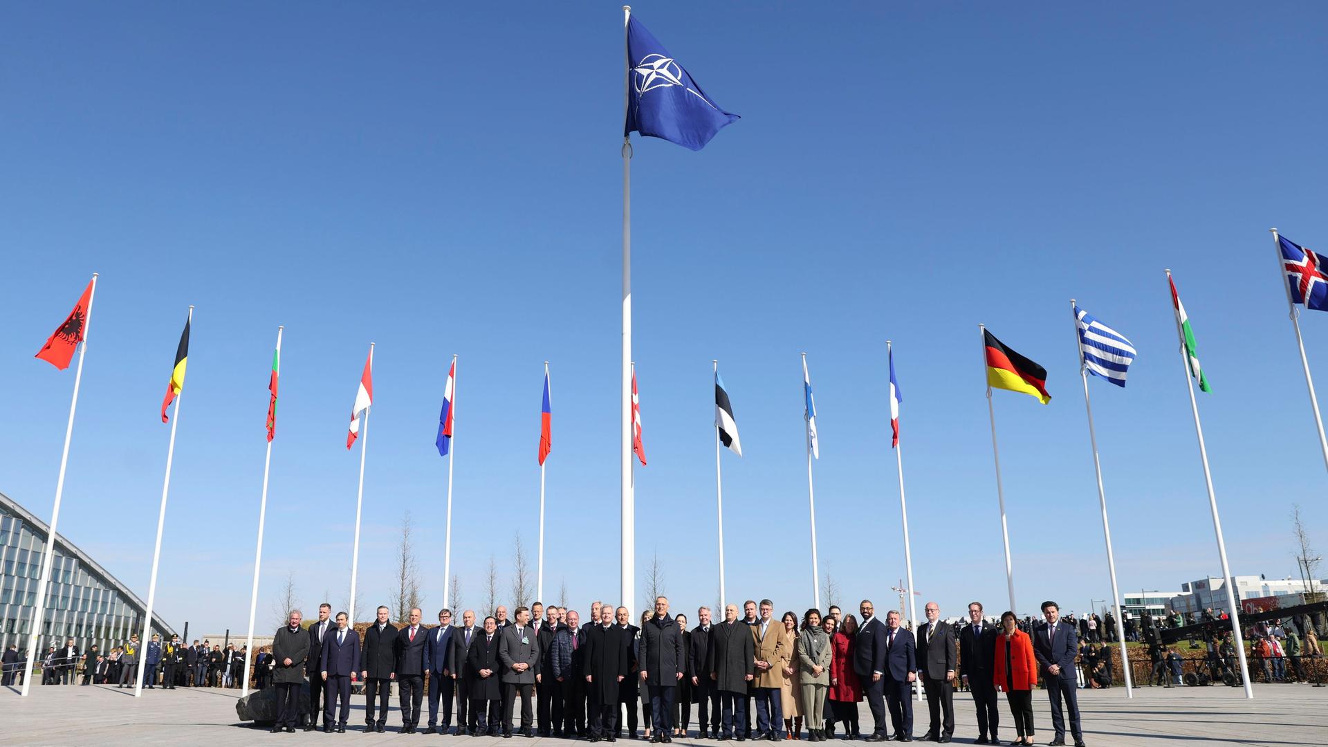 Die NATO-Außenminister stehen vor den Flaggen der Mitgliedsstaaten für ein Foto zusammen, nachdem die finnische Flagge bei einer Zeremonie am Rande des Außenministertreffens am Hauptquartier gehisst wurde.