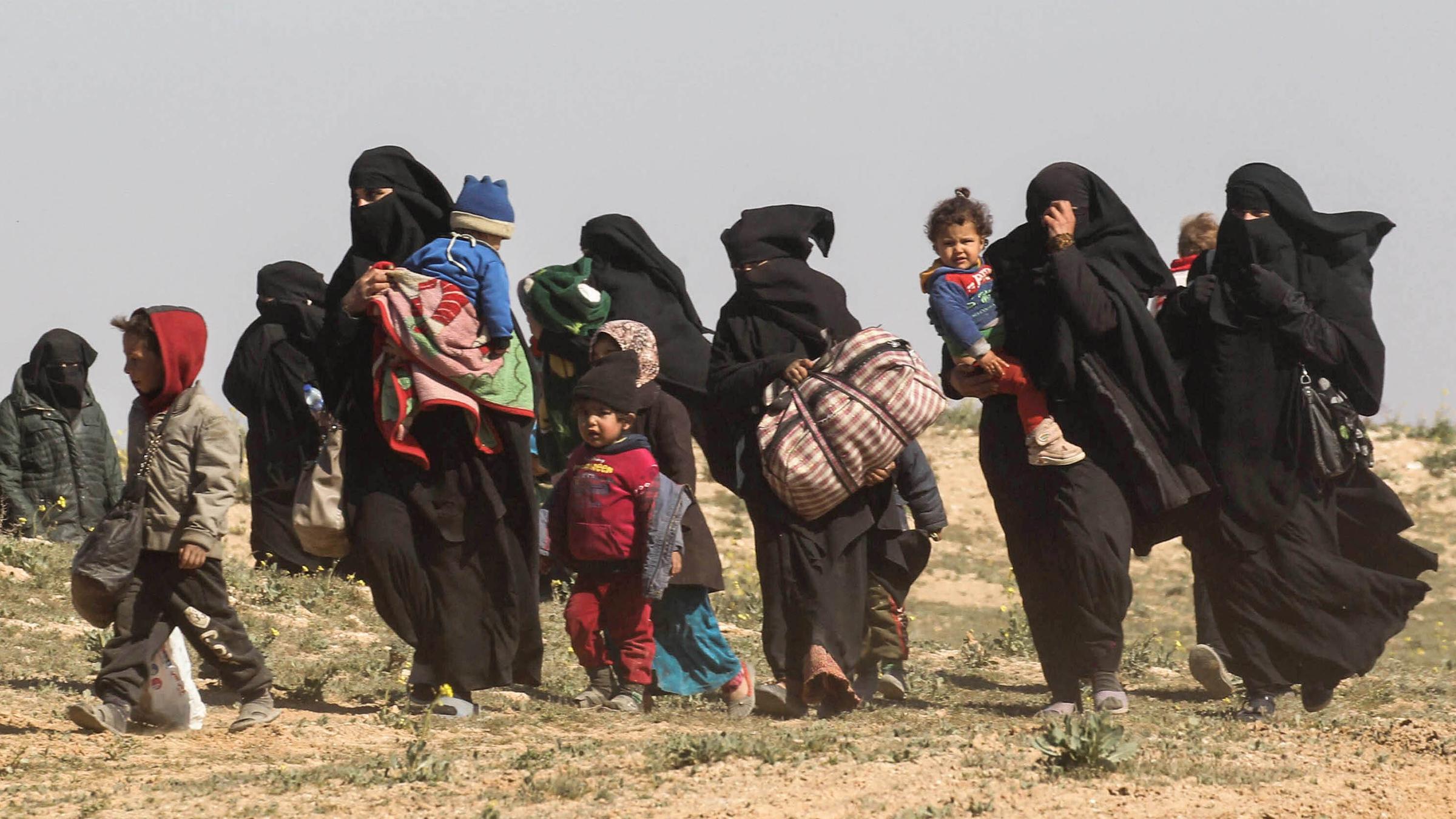 Verhüllte Frauen und Kinder auf freiem Feld im Osten Syriens.  
