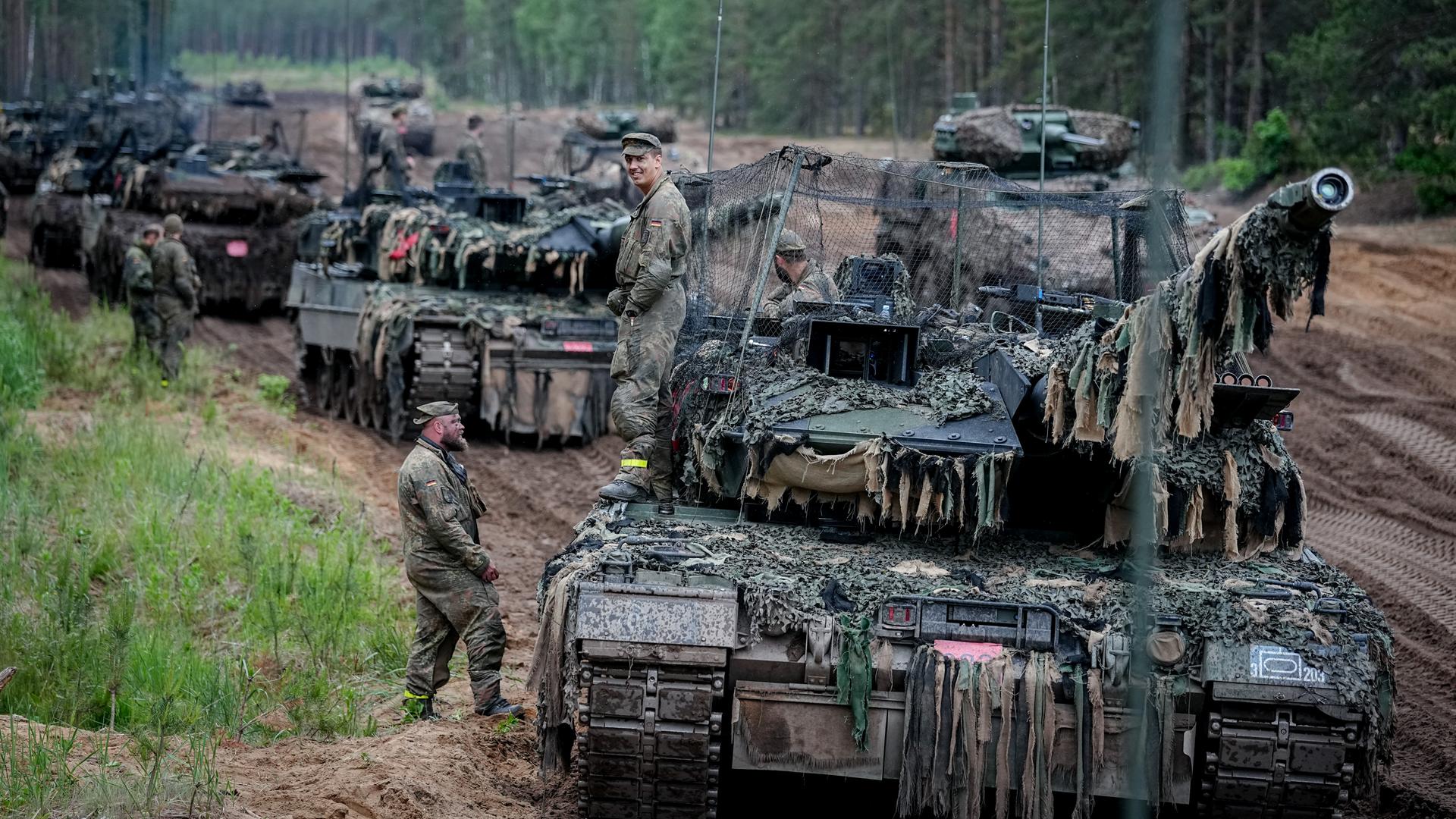 Litauen, Pabrade: Die Besatzung eines Leopard 2 Kampfpanzers mit Drohnenabwehrnetz wartet bei der Gefechtsübung "Freedom Shield 2026" in Litauen auf die Weiterfahrt. Litauen, Pabrade: Die Besatzung eines Leopard 2 Kampfpanzers mit Drohnenabwehrnetz wartet bei der Gefechtsübung "Freedom Shield 2026" in Litauen auf die Weiterfahrt.