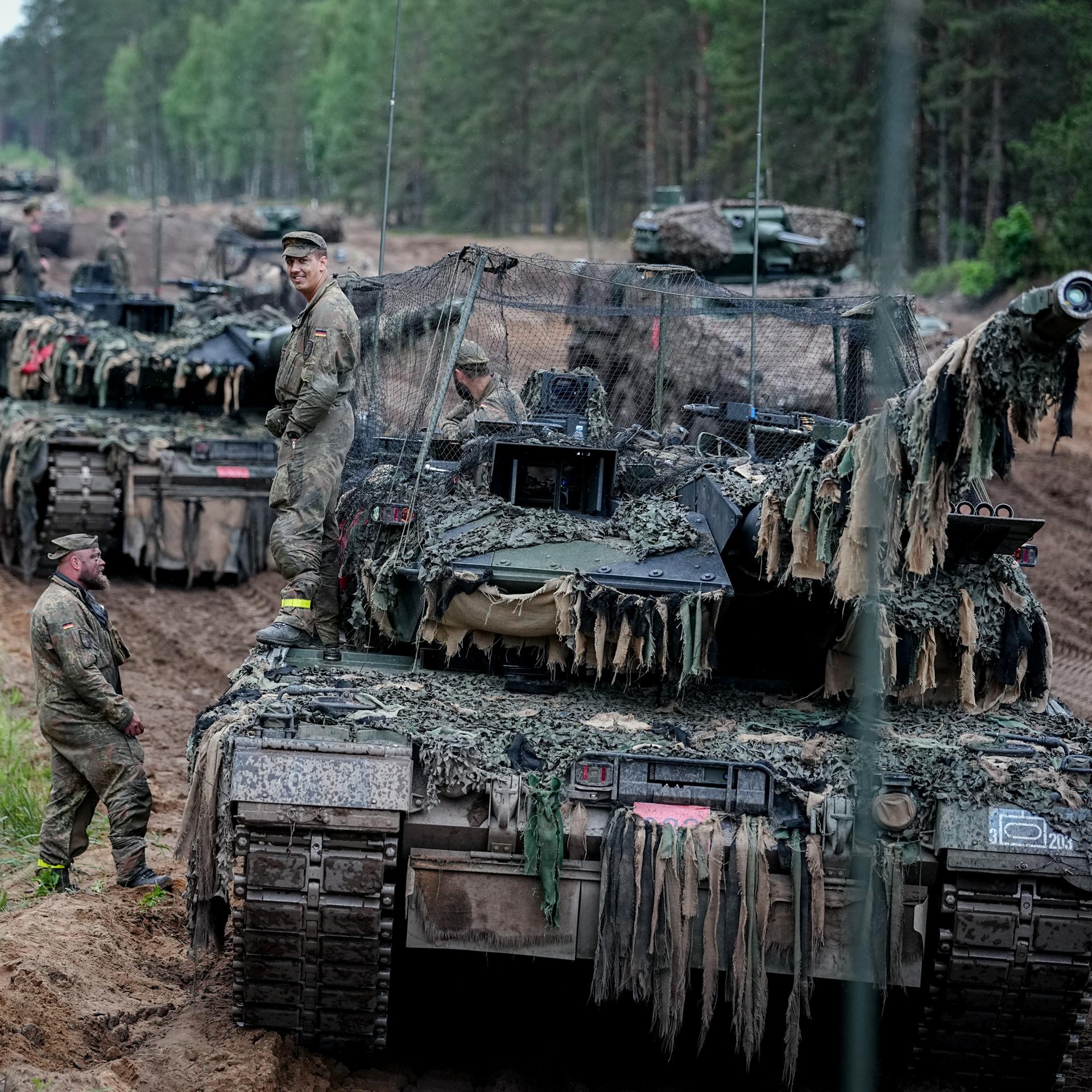 Litauen, Pabrade: Die Besatzung eines Leopard 2 Kampfpanzers mit Drohnenabwehrnetz  wartet bei der Gefechtsübung "Freedom Shield 2026" in Litauen auf die Weiterfahrt. 