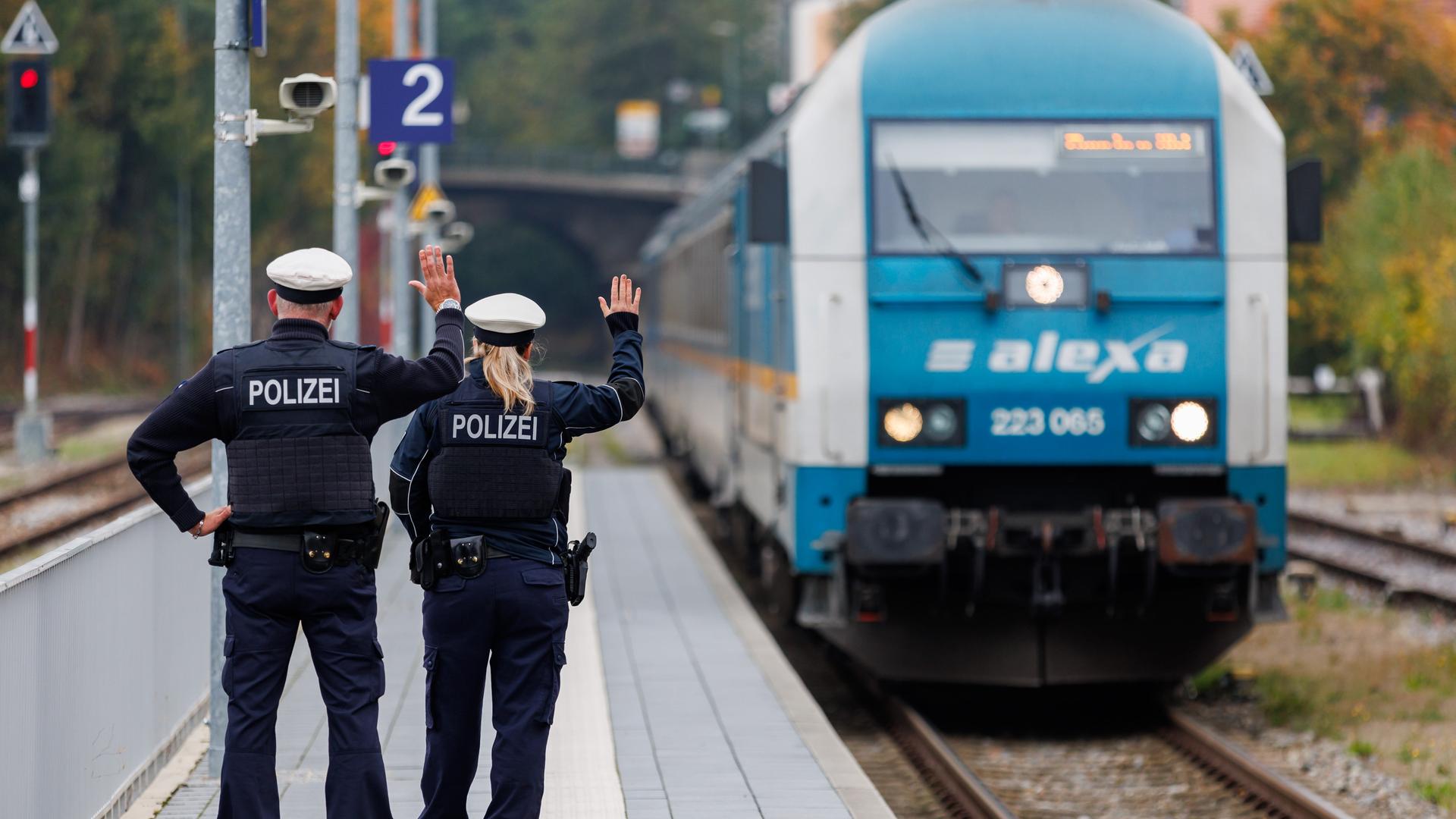 Bundespolizisten weisen per Handzeichen den Lokführer eines Zuges aus Prag in Richtung München darauf hin, dass sie zur Kontrolle des Einreiseverkehrs zusteigen werden.