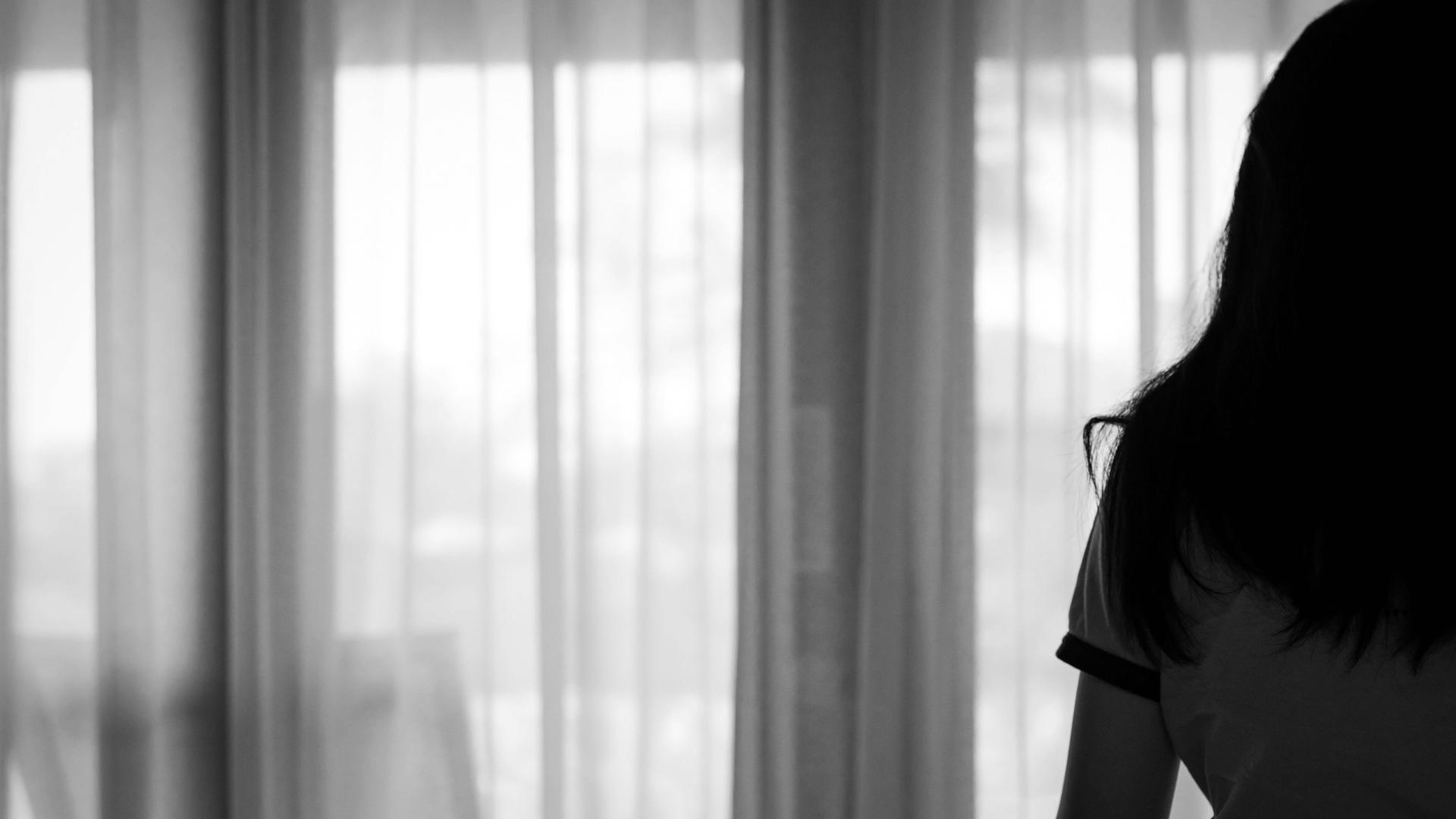 Eine Person steht in einem Zimmer. Man sieht sie von hinten. Eine Person steht in einem Zimmer. Man sieht sie von hinten.