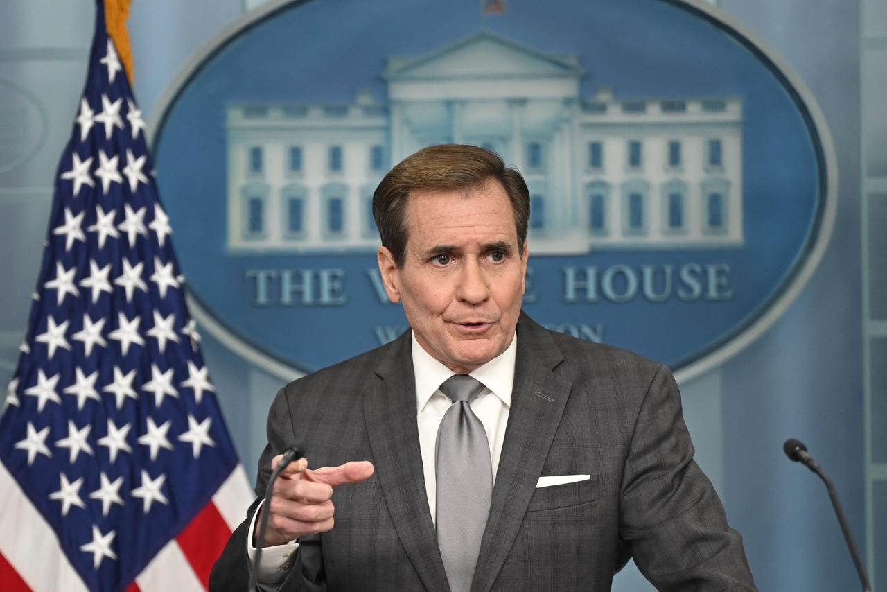 John Kirby spricht bei einer Pressekonferenz im Weißen Haus. Links neben ihm ist die US-Flagge zu sehen, im Hintergrund ein Bild des Weißen Hauses. 